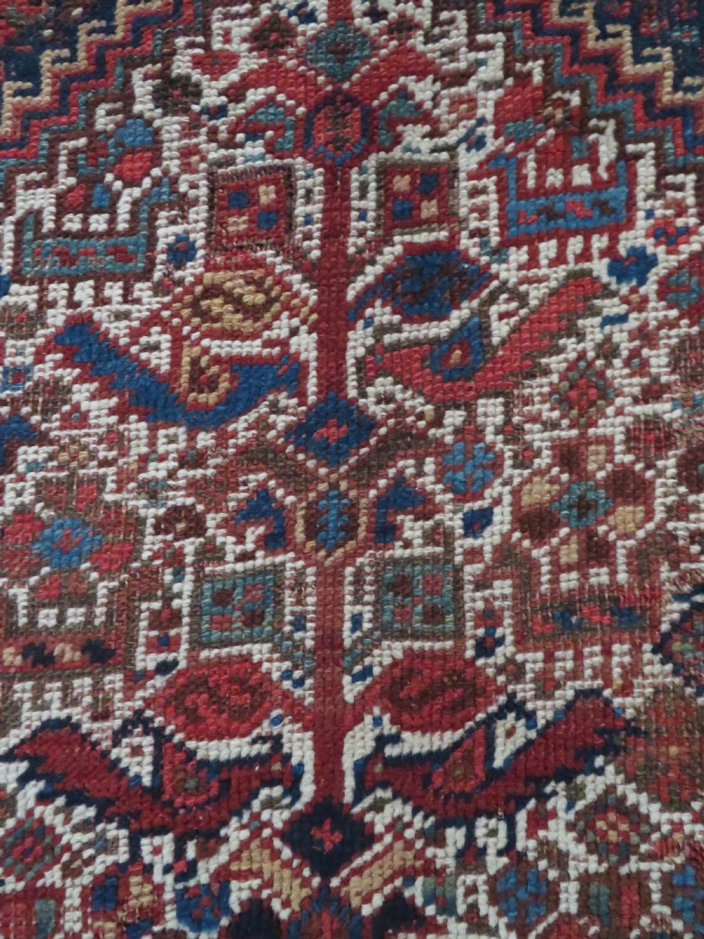 An antique hand-knotted Persian Khamseh rug featuring three diamond central medallions and bird motifs in deep red, navy, cream, and terracotta tones. View XII