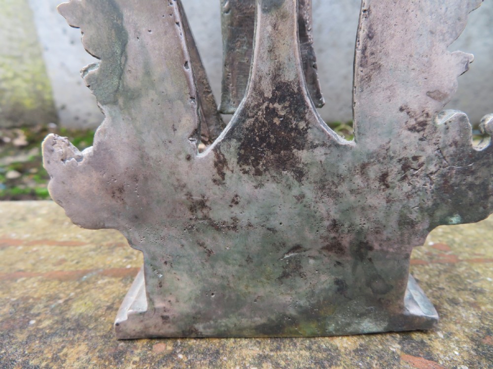 An ancient cast metal figure of Vishnu standing within a flame-edged aureole on a lotus base above a small figure. View XV