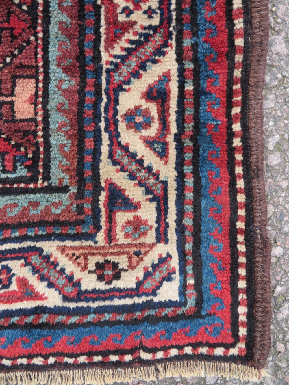 An antique hand-knotted Quchan Kurdish wool rug displaying a central diamond pattern inside a dark red and navy lattice grid with geometric borders. View IV