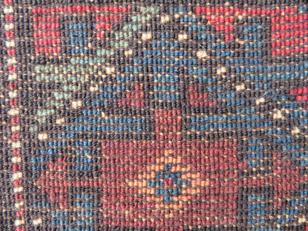 An antique hand-knotted Quchan Kurdish wool rug displaying a central diamond pattern inside a dark red and navy lattice grid with geometric borders. View IX