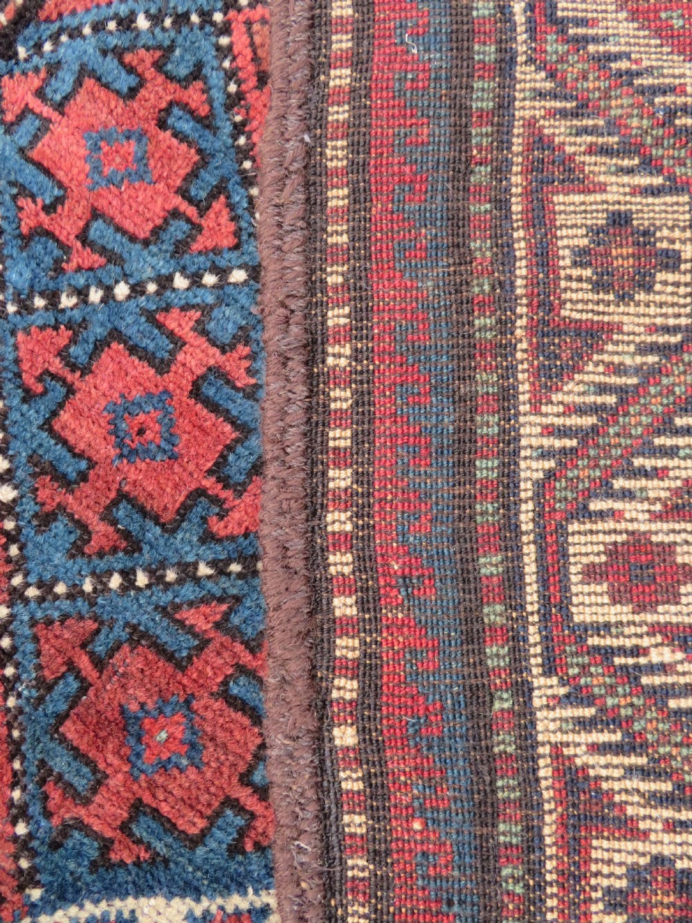 An antique hand-knotted Quchan Kurdish wool rug displaying a central diamond pattern inside a dark red and navy lattice grid with geometric borders. View X