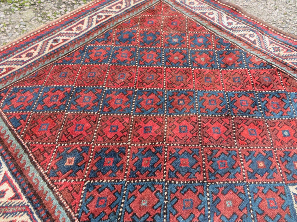 An antique hand-knotted Quchan Kurdish wool rug displaying a central diamond pattern inside a dark red and navy lattice grid with geometric borders. View XII