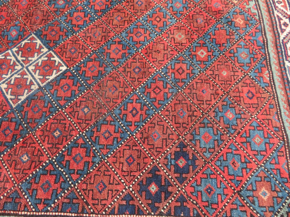 An antique hand-knotted Quchan Kurdish wool rug displaying a central diamond pattern inside a dark red and navy lattice grid with geometric borders. View XIII