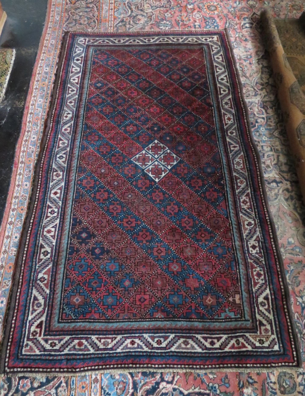 An antique hand-knotted Quchan Kurdish wool rug displaying a central diamond pattern inside a dark red and navy lattice grid with geometric borders. View XVI