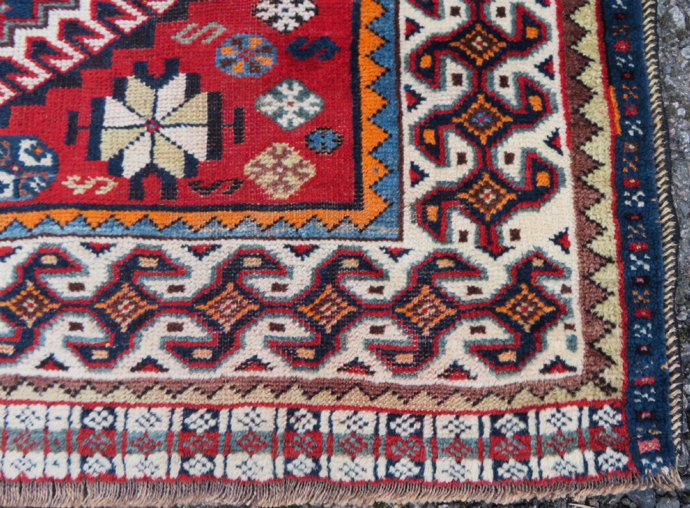 A handwoven Luri tribal rug featuring double geometric diamond medallions in navy blue and red with multi-layered patterned borders. View XVI