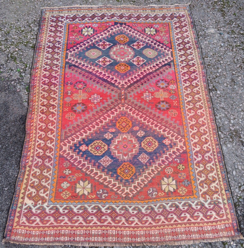 A handwoven Luri tribal rug featuring double geometric diamond medallions in navy blue and red with multi-layered patterned borders. View XVIII