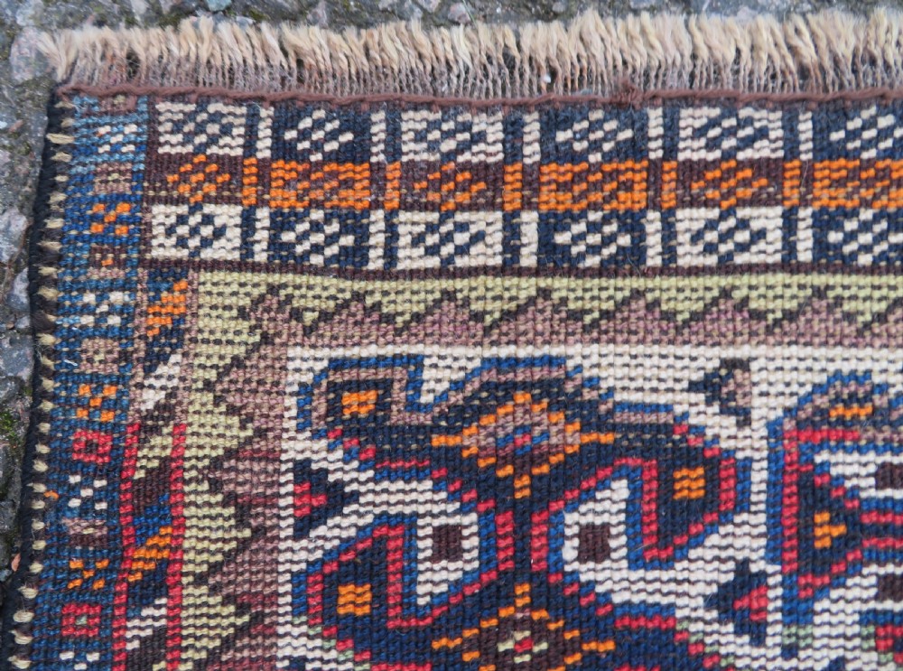 A handwoven Luri tribal rug featuring double geometric diamond medallions in navy blue and red with multi-layered patterned borders. View XIX