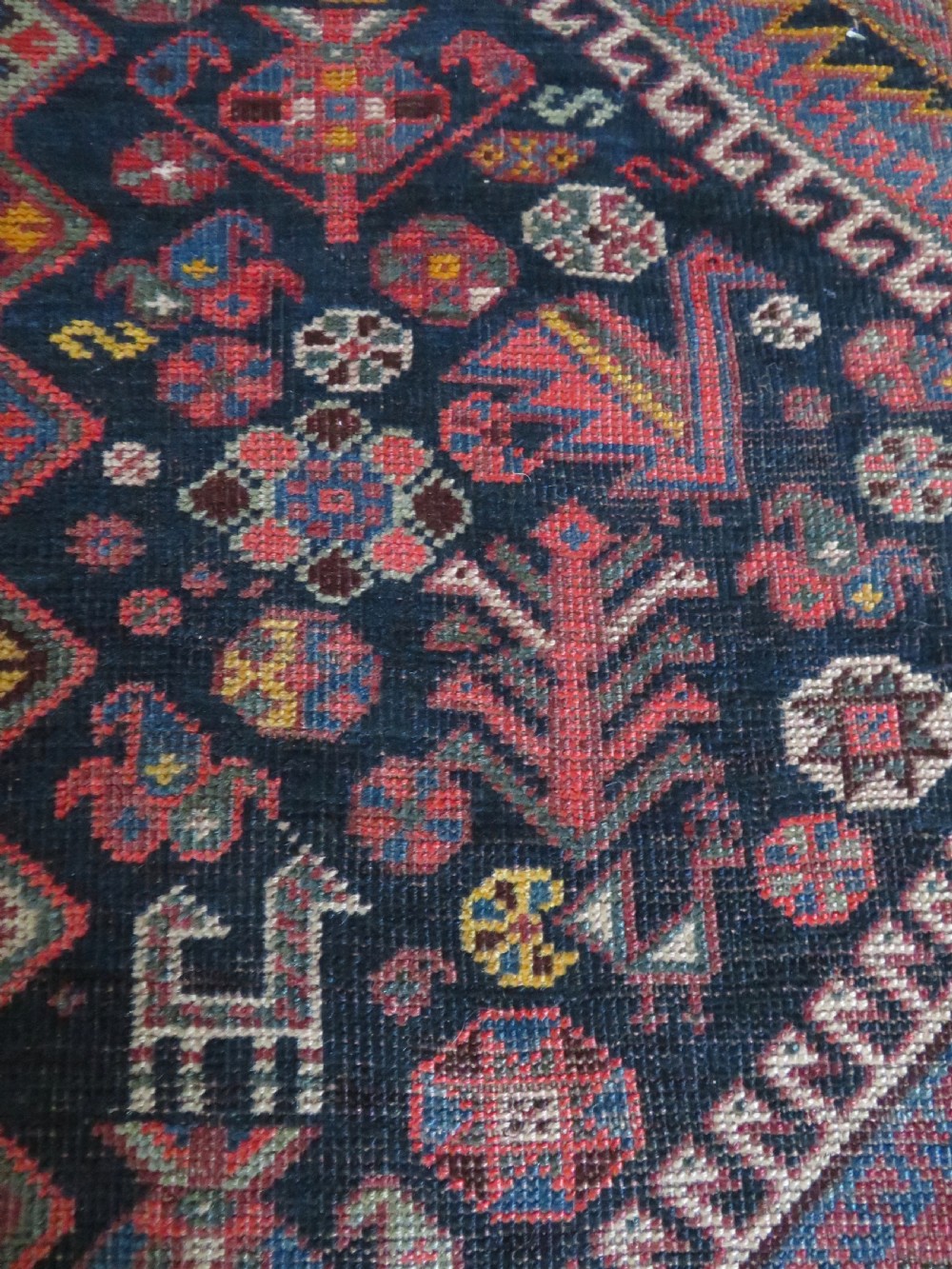 An antique hand-knotted Qashqai wool rug featuring three diamond central medallions with tribal peacock motifs in red, blue, and magenta tones. View XI