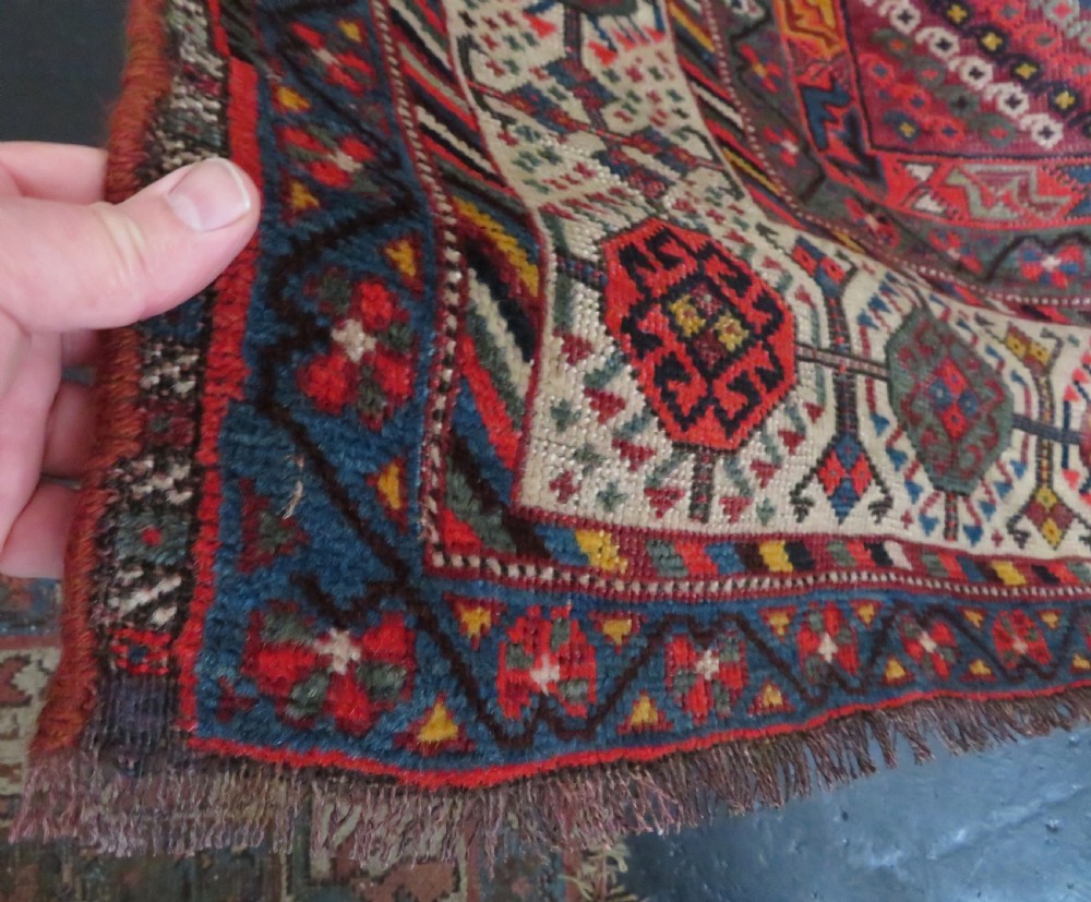 An antique hand-knotted Qashqai wool rug featuring three diamond central medallions with tribal peacock motifs in red, blue, and magenta tones. View XIII