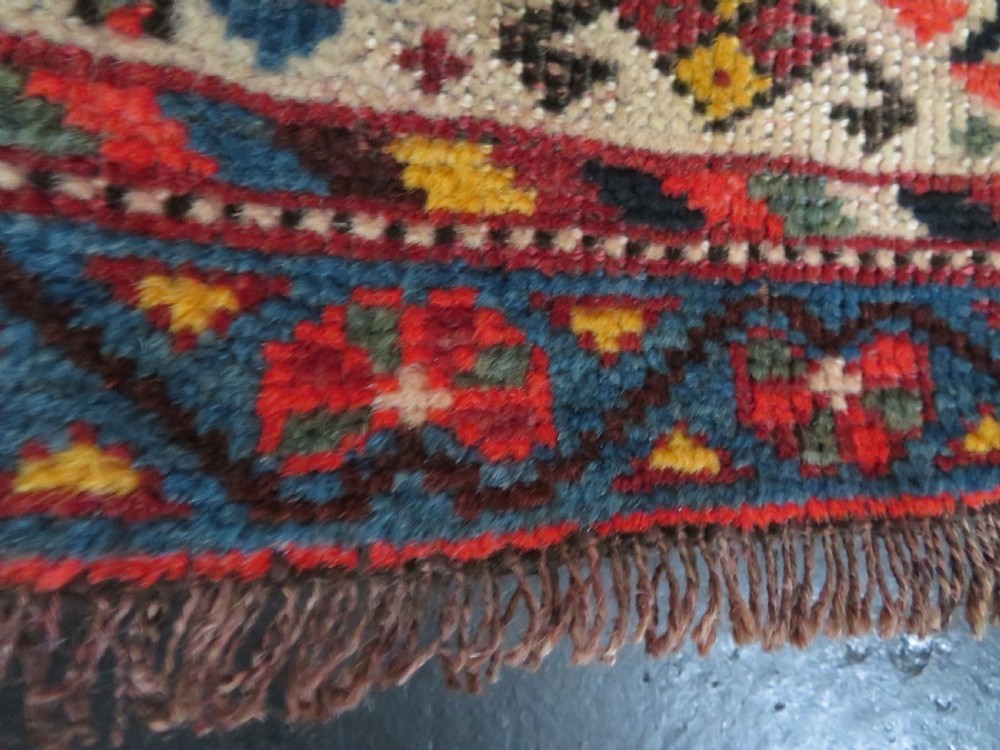 An antique hand-knotted Qashqai wool rug featuring three diamond central medallions with tribal peacock motifs in red, blue, and magenta tones. View XIV