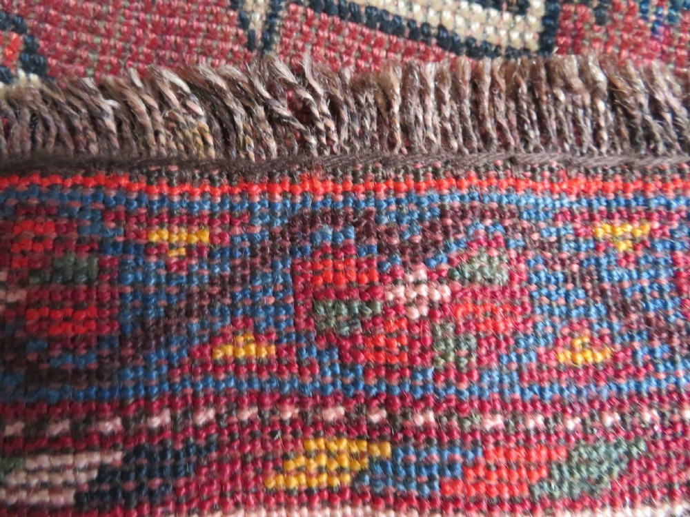 An antique hand-knotted Qashqai wool rug featuring three diamond central medallions with tribal peacock motifs in red, blue, and magenta tones. View XVIII
