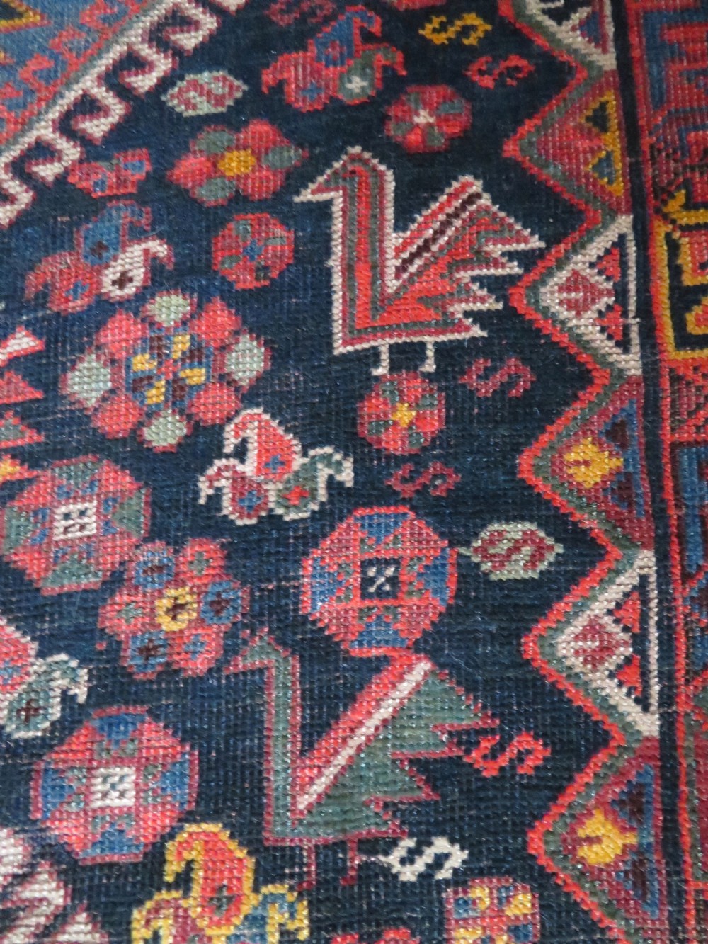 An antique hand-knotted Qashqai wool rug featuring three diamond central medallions with tribal peacock motifs in red, blue, and magenta tones. View XIX