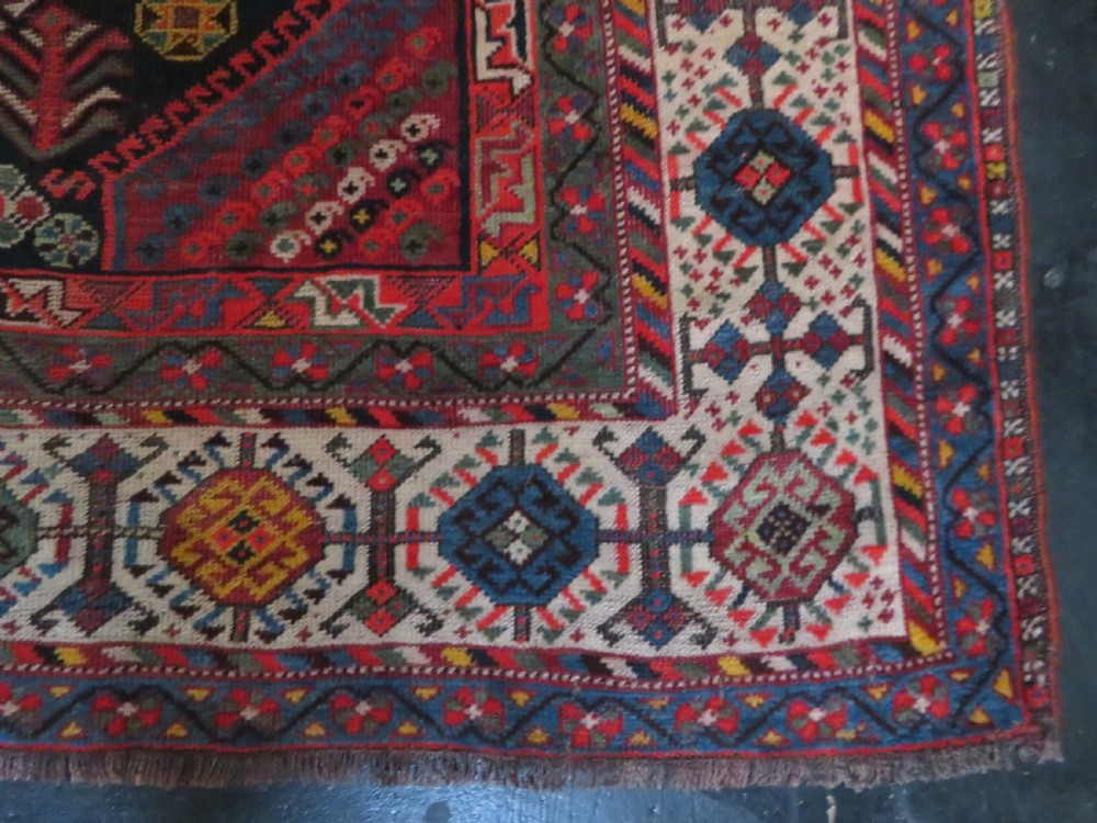 An antique hand-knotted Qashqai wool rug featuring three diamond central medallions with tribal peacock motifs in red, blue, and magenta tones. View XXIV