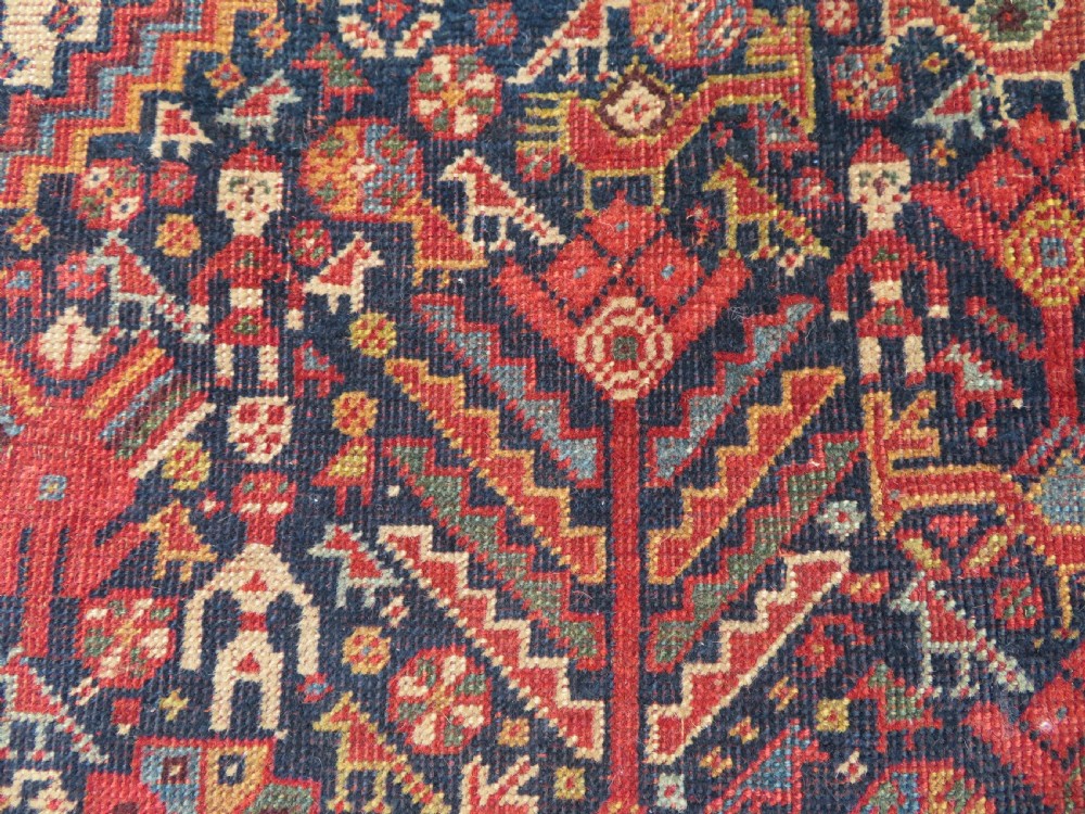 A nineteenth-century hand-knotted Khamseh tribal carpet featuring three diamond-shaped central medallions on an indigo blue field surrounded by geometric borders. View VII