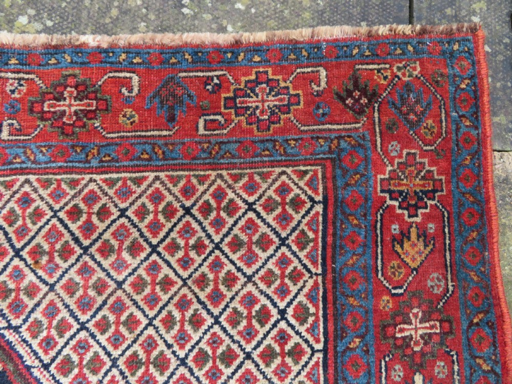 A nineteenth-century hand-knotted Khamseh tribal carpet featuring three diamond-shaped central medallions on an indigo blue field surrounded by geometric borders. View XI
