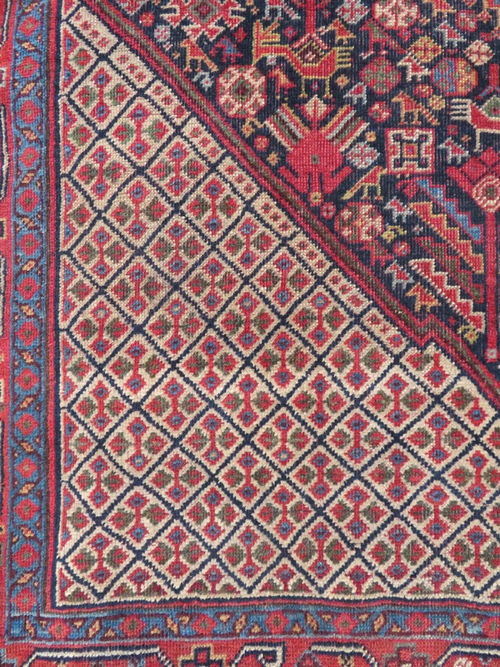 A nineteenth-century hand-knotted Khamseh tribal carpet featuring three diamond-shaped central medallions on an indigo blue field surrounded by geometric borders. View XIV