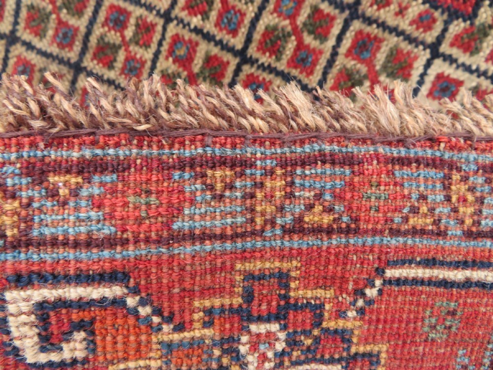 A nineteenth-century hand-knotted Khamseh tribal carpet featuring three diamond-shaped central medallions on an indigo blue field surrounded by geometric borders. View XVII