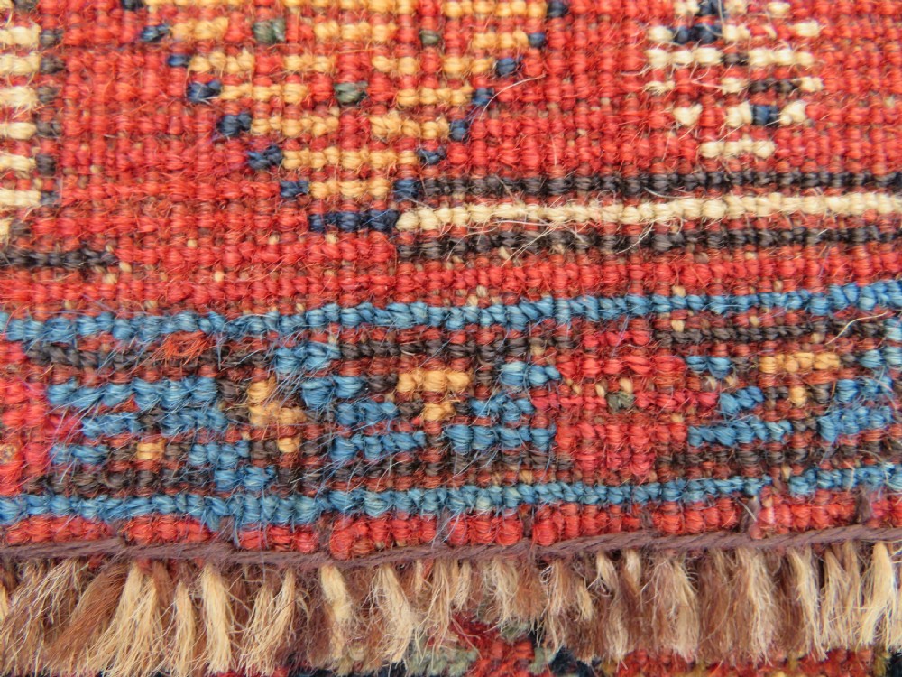 A nineteenth-century hand-knotted Khamseh tribal carpet featuring three diamond-shaped central medallions on an indigo blue field surrounded by geometric borders. View XXI