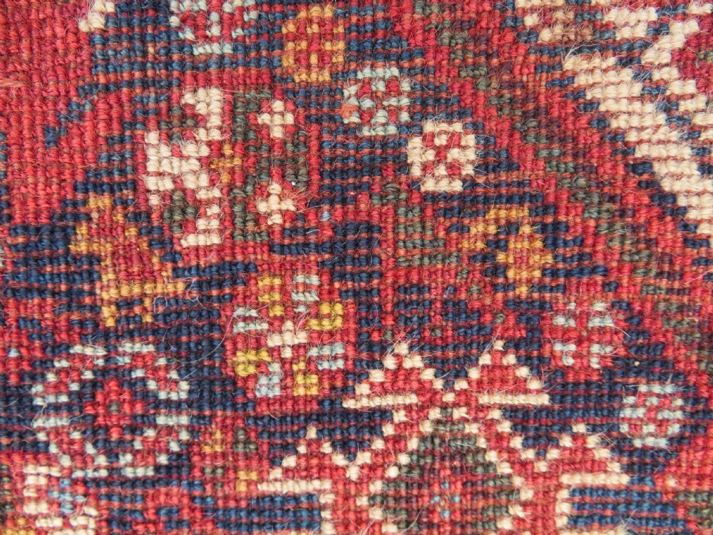 A nineteenth-century hand-knotted Khamseh tribal carpet featuring three diamond-shaped central medallions on an indigo blue field surrounded by geometric borders. View XXII