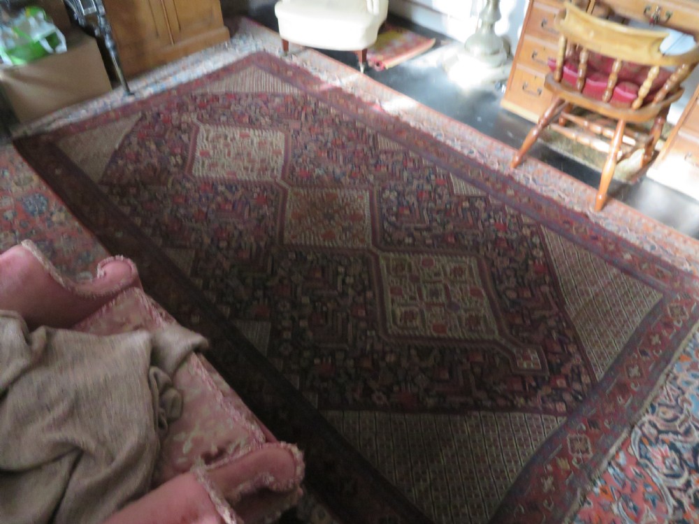 A nineteenth-century hand-knotted Khamseh tribal carpet featuring three diamond-shaped central medallions on an indigo blue field surrounded by geometric borders. View XXVIII