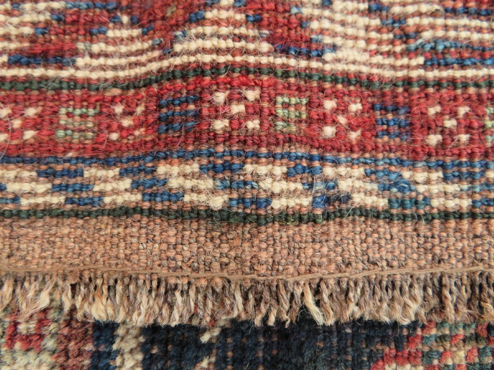 An antique hand-knotted Persian tribal rug featuring three central diamond-shaped medallions, geometric peacock motifs, and multi-layered borders in navy blue, red, and ivory wool. View XII