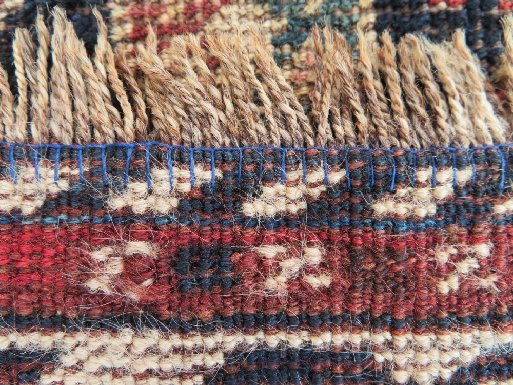 An antique hand-knotted Persian tribal rug featuring three central diamond-shaped medallions, geometric peacock motifs, and multi-layered borders in navy blue, red, and ivory wool. View XIII
