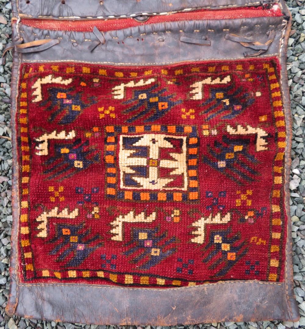 A late 19th-century Eastern Anatolian Yuruk double saddlebag woven in red, navy, and orange geometric wool patterns with leather binding. View II