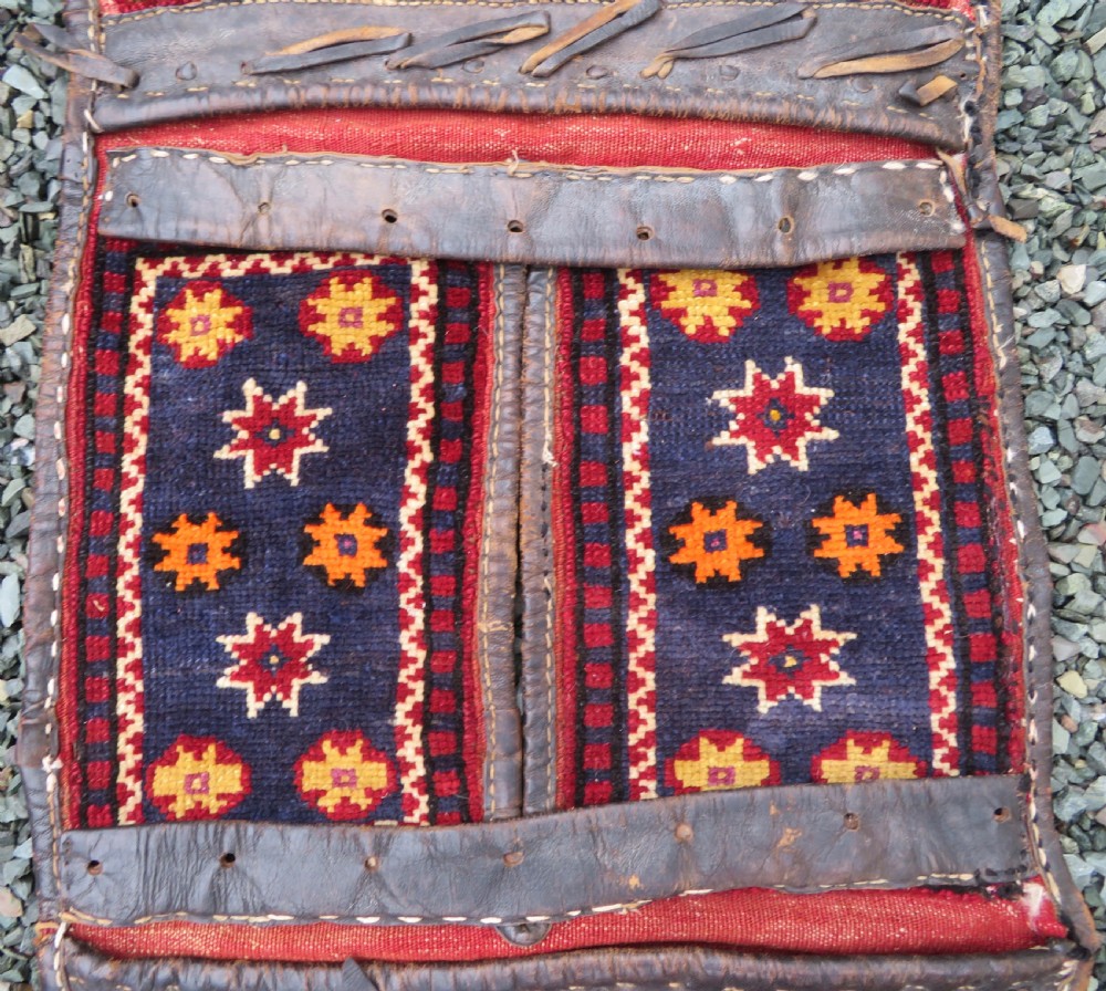 A late 19th-century Eastern Anatolian Yuruk double saddlebag woven in red, navy, and orange geometric wool patterns with leather binding. View III