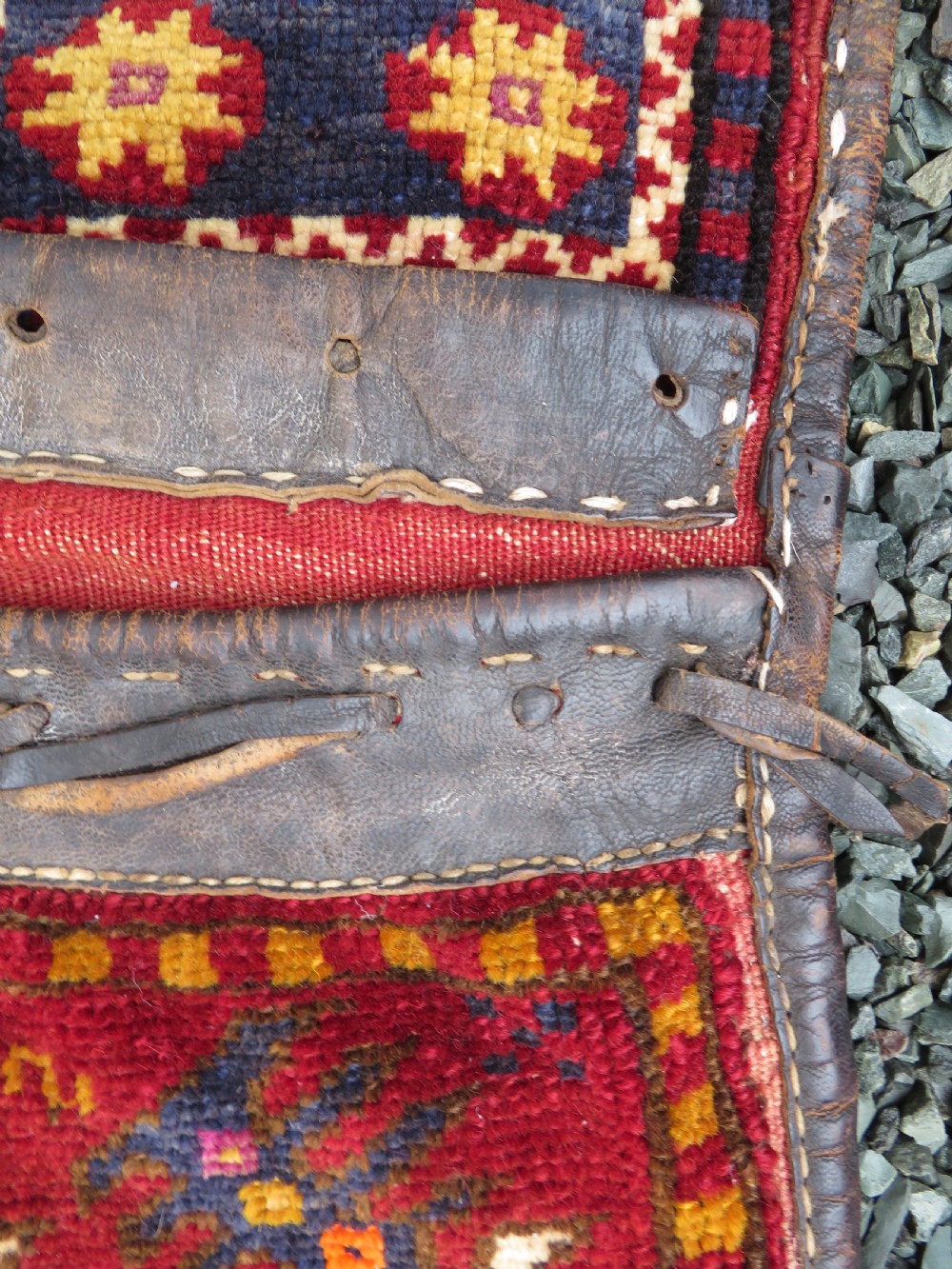 A late 19th-century Eastern Anatolian Yuruk double saddlebag woven in red, navy, and orange geometric wool patterns with leather binding. View V