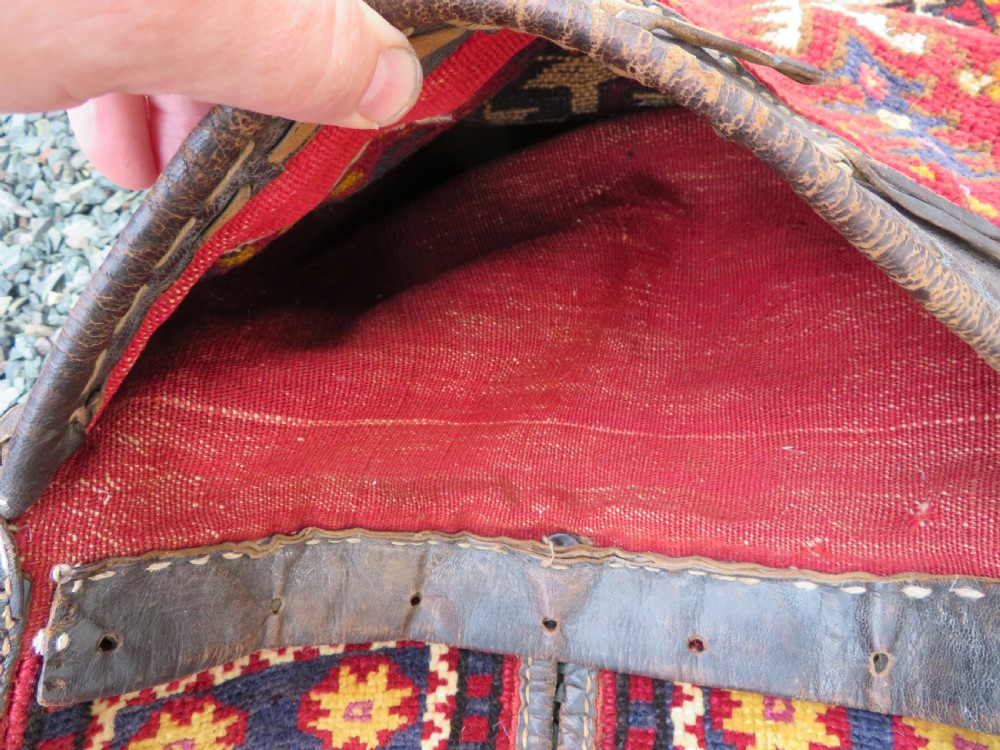 A late 19th-century Eastern Anatolian Yuruk double saddlebag woven in red, navy, and orange geometric wool patterns with leather binding. View VI