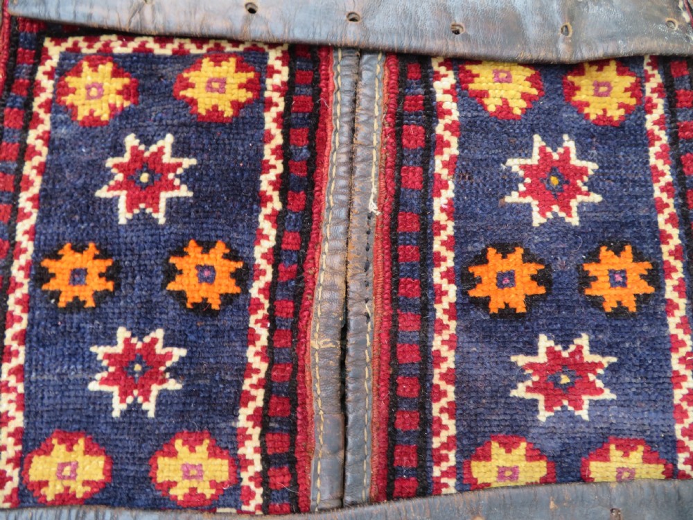 A late 19th-century Eastern Anatolian Yuruk double saddlebag woven in red, navy, and orange geometric wool patterns with leather binding. View VII
