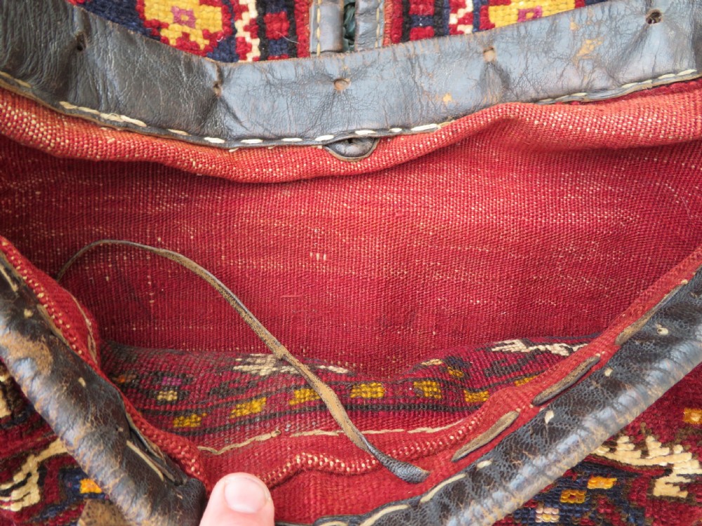 A late 19th-century Eastern Anatolian Yuruk double saddlebag woven in red, navy, and orange geometric wool patterns with leather binding. View VIII
