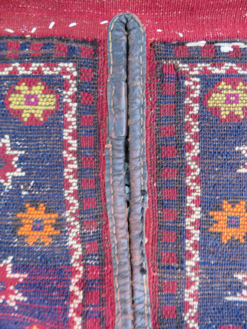 A late 19th-century Eastern Anatolian Yuruk double saddlebag woven in red, navy, and orange geometric wool patterns with leather binding. View XIV