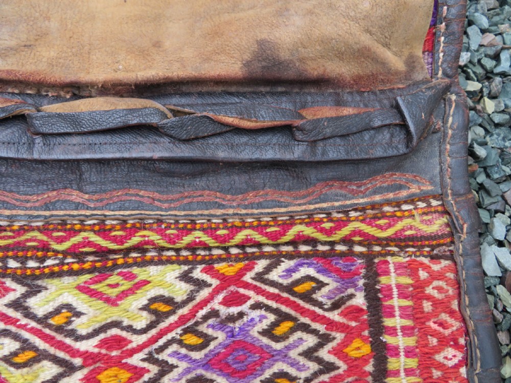 A late 19th-century Shahsavan Persian double saddle bag featuring dark leather flaps and central multi-coloured striped wool flatweave panels. View V