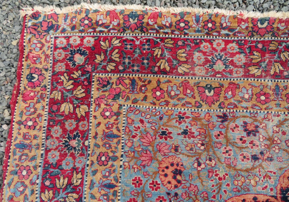 An antique hand-knotted Persian Kerman prayer rug featuring a dark central niche filled with millefleurs floral motifs and a crimson border. View XIII