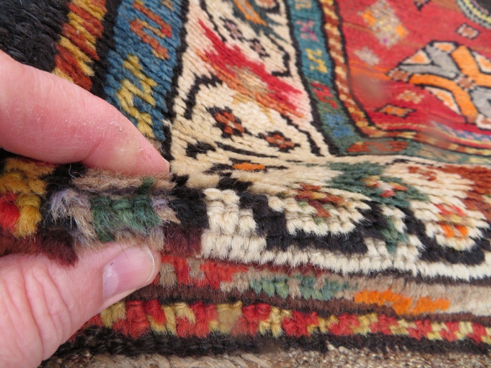 An antique hand-knotted Caucasian Karabagh Chondoresk long runner featuring bold geometric cloudband medallions in shades of red, black, and cream with an ornate decorative border. View VI