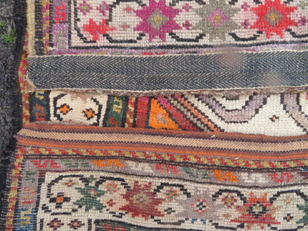 An antique hand-knotted Caucasian Karabagh Chondoresk long runner featuring bold geometric cloudband medallions in shades of red, black, and cream with an ornate decorative border. View IX