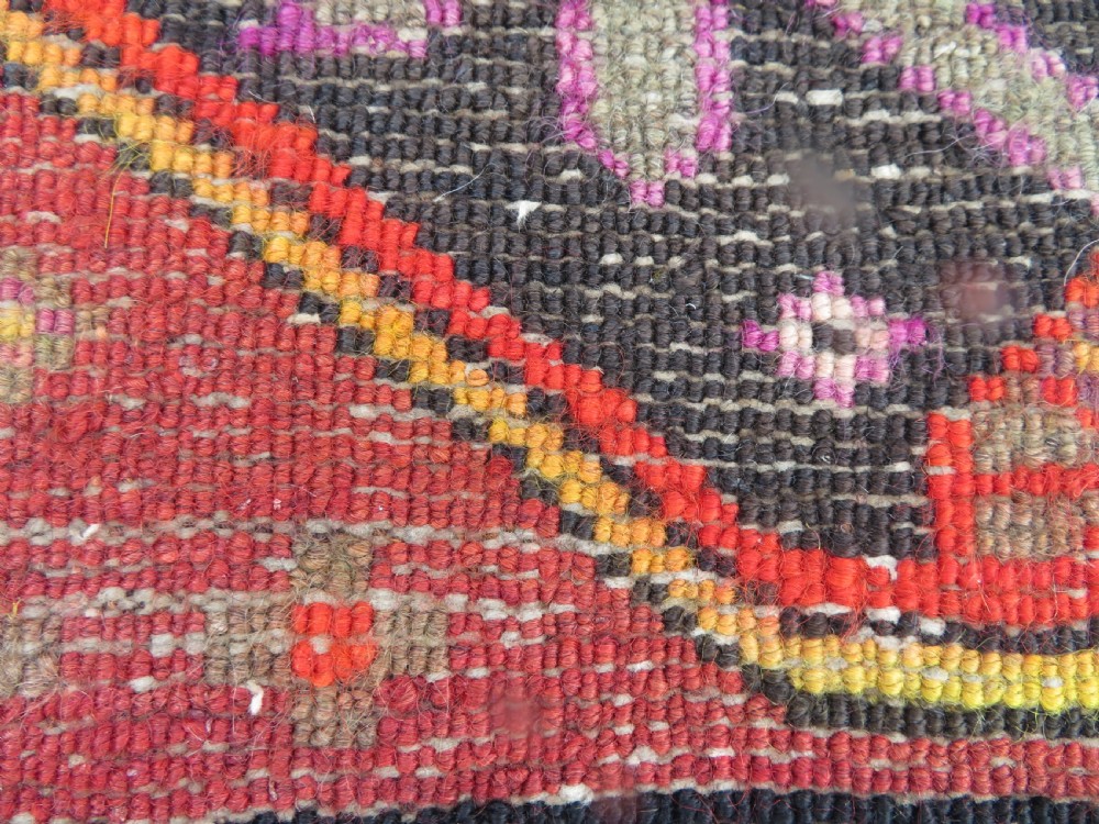 An antique hand-knotted Caucasian Karabagh Chondoresk long runner featuring bold geometric cloudband medallions in shades of red, black, and cream with an ornate decorative border. View X