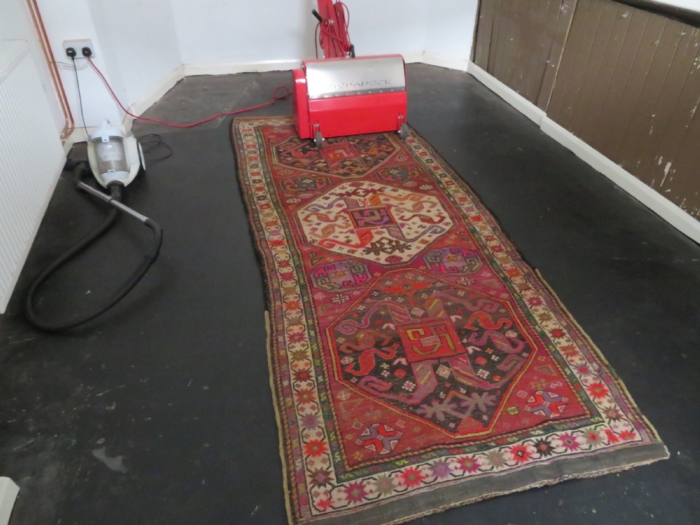 An antique hand-knotted Caucasian Karabagh Chondoresk long runner featuring bold geometric cloudband medallions in shades of red, black, and cream with an ornate decorative border. View XIX