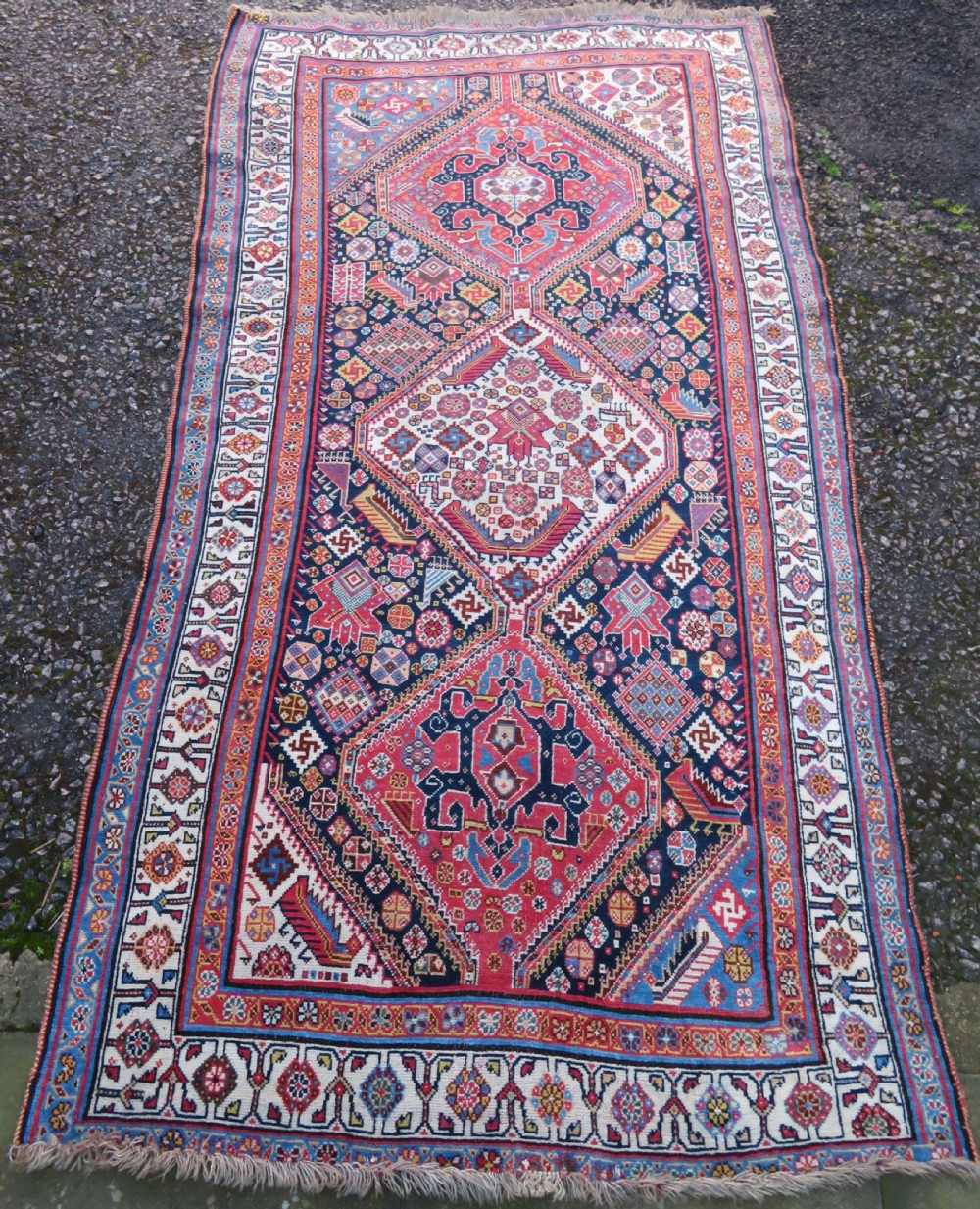 An antique hand-knotted Qashqai Kashkuli wool rug featuring three stacked diamond medallions in red, indigo blue, and ivory surrounded by intricate geometric borders. View II