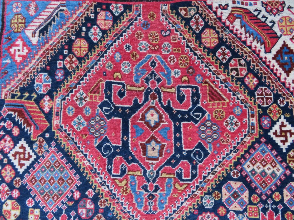 An antique hand-knotted Qashqai Kashkuli wool rug featuring three stacked diamond medallions in red, indigo blue, and ivory surrounded by intricate geometric borders. View III