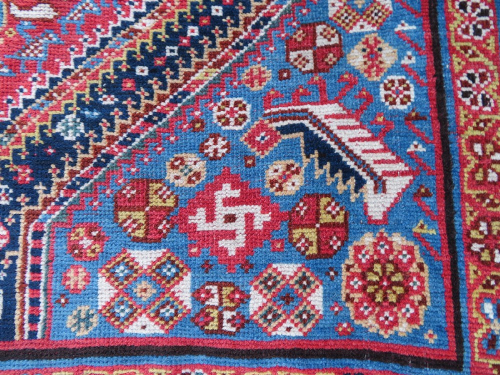 An antique hand-knotted Qashqai Kashkuli wool rug featuring three stacked diamond medallions in red, indigo blue, and ivory surrounded by intricate geometric borders. View XV