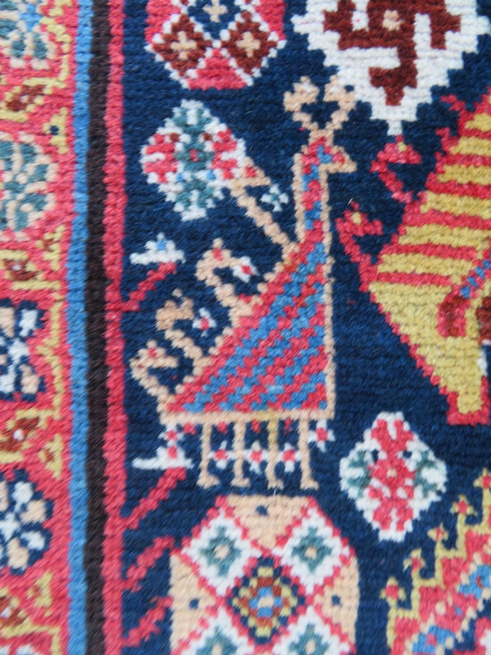 An antique hand-knotted Qashqai Kashkuli wool rug featuring three stacked diamond medallions in red, indigo blue, and ivory surrounded by intricate geometric borders. View XVIII