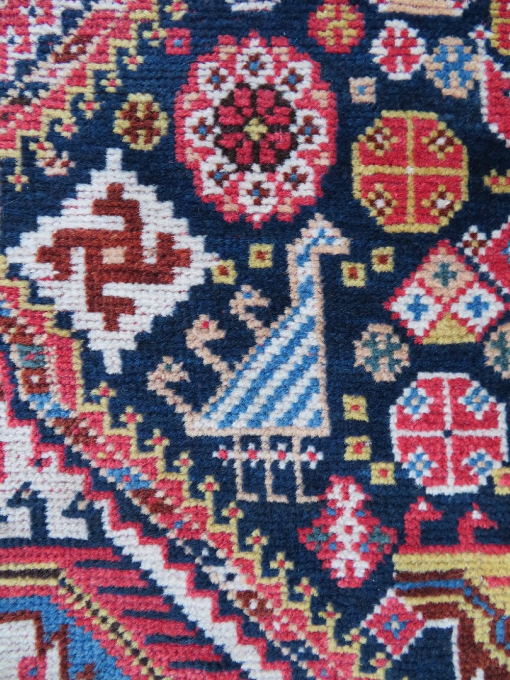 An antique hand-knotted Qashqai Kashkuli wool rug featuring three stacked diamond medallions in red, indigo blue, and ivory surrounded by intricate geometric borders. View XIX