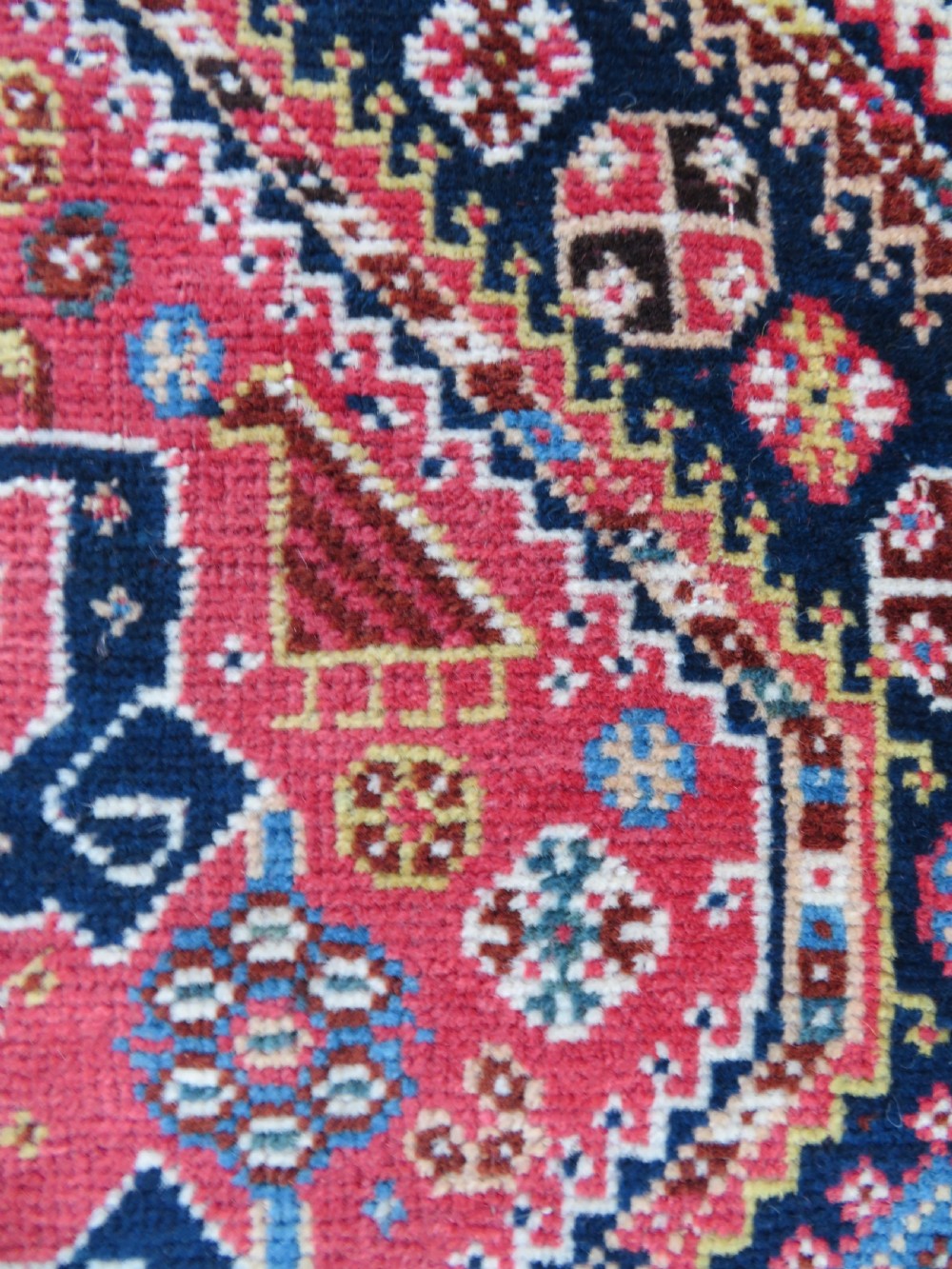 An antique hand-knotted Qashqai Kashkuli wool rug featuring three stacked diamond medallions in red, indigo blue, and ivory surrounded by intricate geometric borders. View XXI