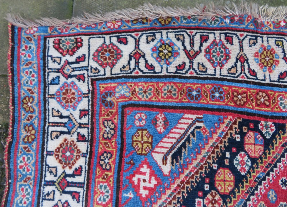 An antique hand-knotted Qashqai Kashkuli wool rug featuring three stacked diamond medallions in red, indigo blue, and ivory surrounded by intricate geometric borders. View XXII