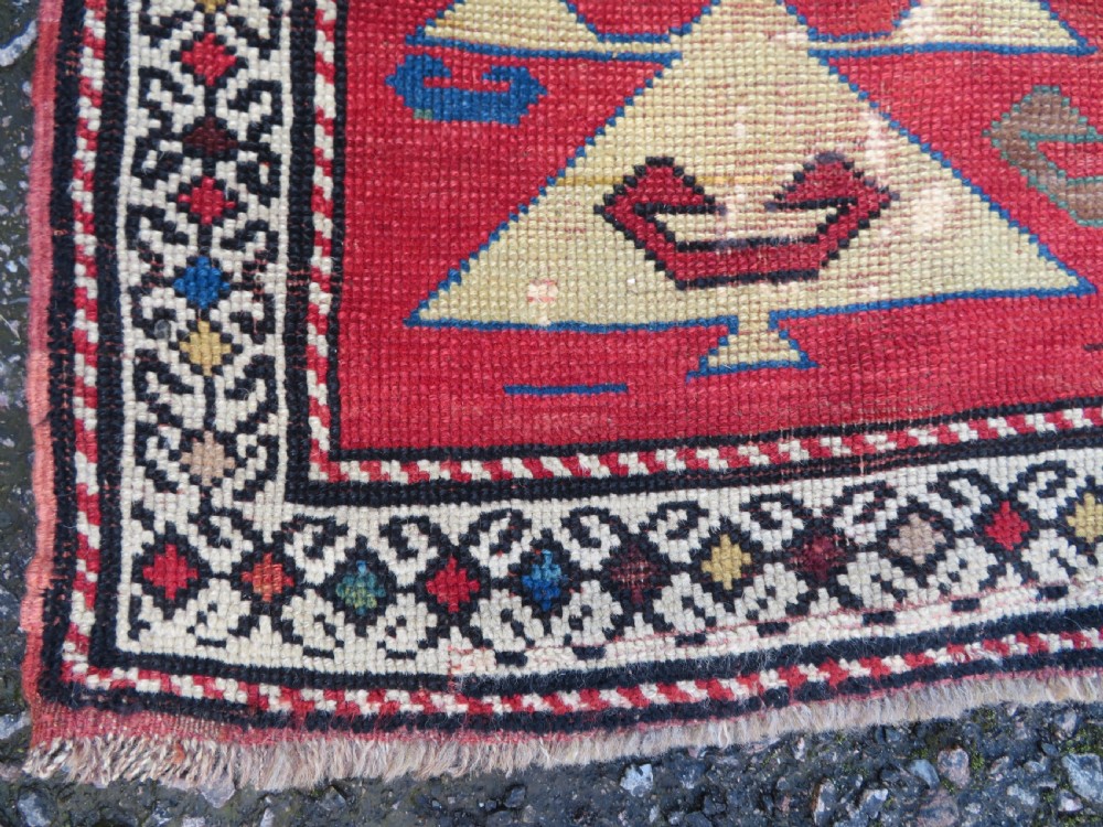 An antique South Caucasian Karabagh hand-knotted wool rug with repeating geometric motifs across a deep red field and a patterned border. View VIII
