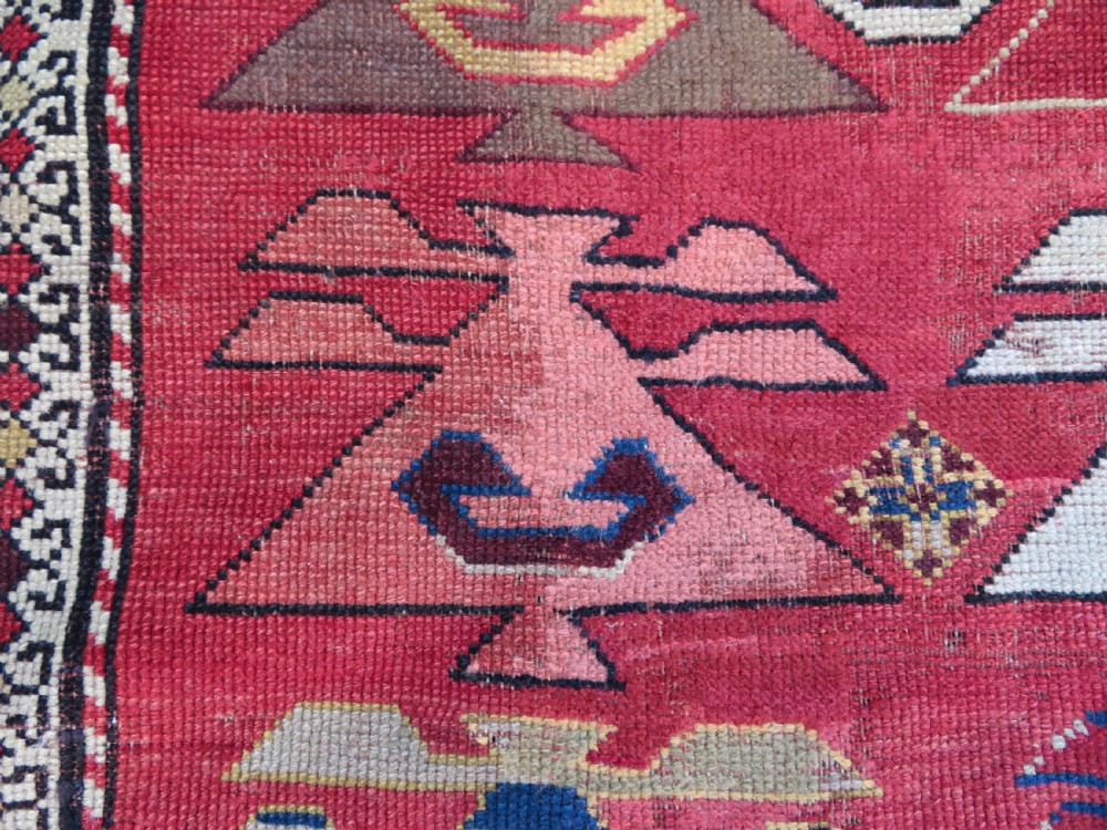 An antique South Caucasian Karabagh hand-knotted wool rug with repeating geometric motifs across a deep red field and a patterned border. View XI