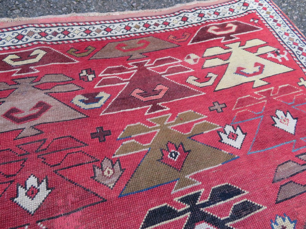 An antique South Caucasian Karabagh hand-knotted wool rug with repeating geometric motifs across a deep red field and a patterned border. View XIII