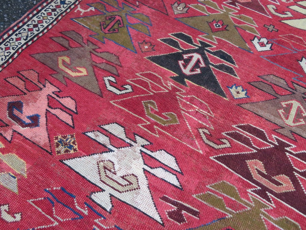 An antique South Caucasian Karabagh hand-knotted wool rug with repeating geometric motifs across a deep red field and a patterned border. View XIV